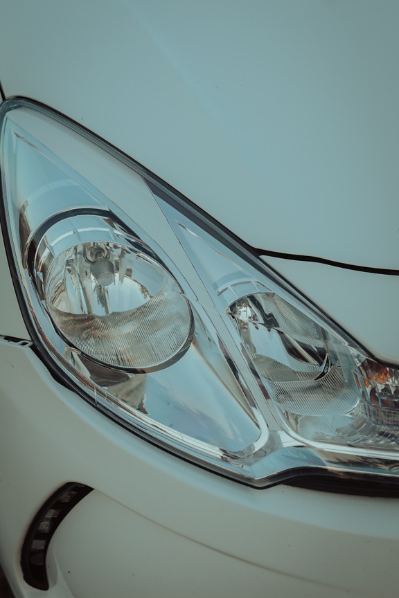 Close-up of headlight of white metallic car