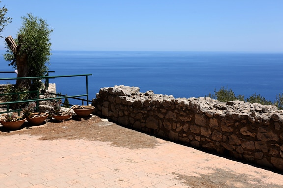 Balkón s kamenným múrom s majestátnou panorámou morskej krajiny