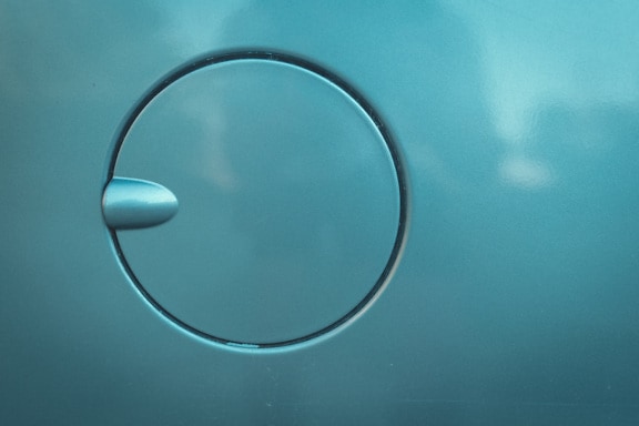 Close-up detail of round fuel filler cap in turquoise metallic paint