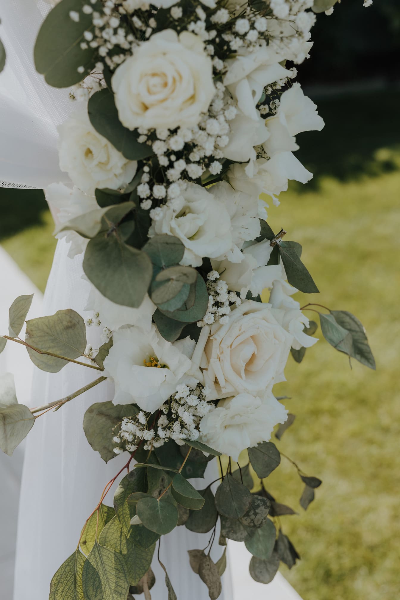 Detail svatební výzdoby s bílými růžemi v zahradě