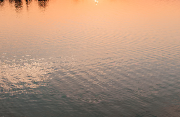 Orange yellow reflection on water calm surface