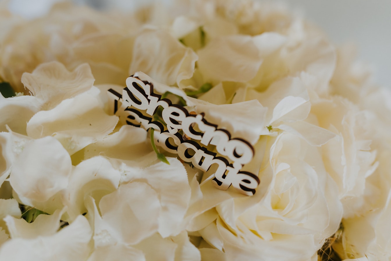 Prim-plan cu buchet de nuntă cu trandafiri albi și decorațiuni