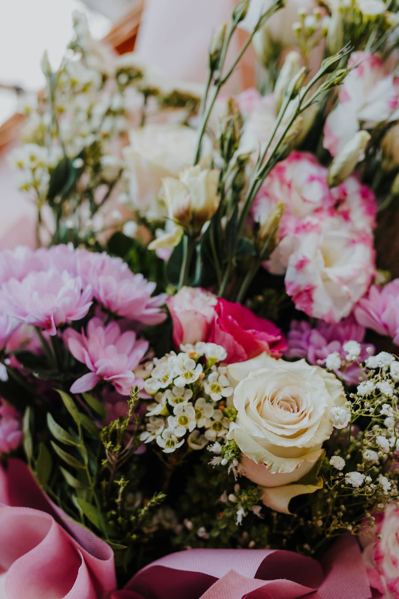 Nærbilde av vakker bukett med rosa blomster og hvite roser