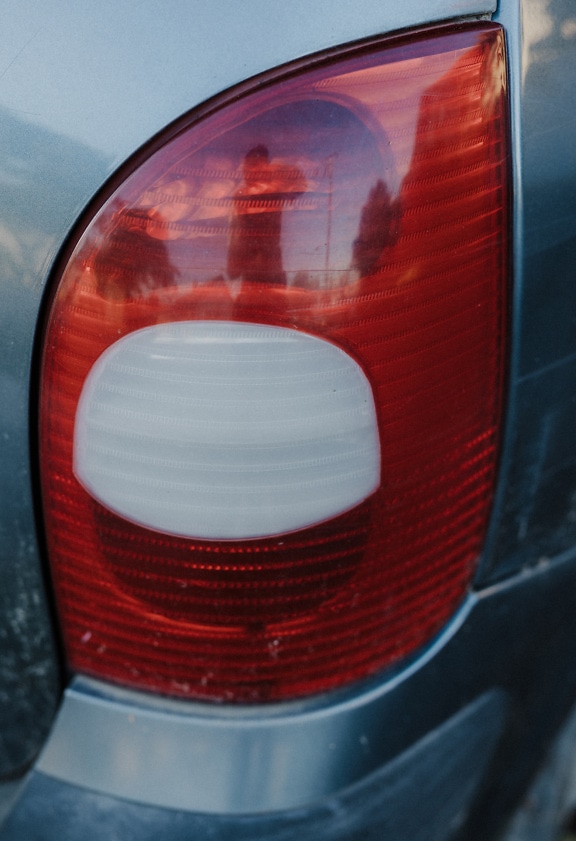 Detail lampu belakang pada kendaraan dengan plastik putih dan merah tua