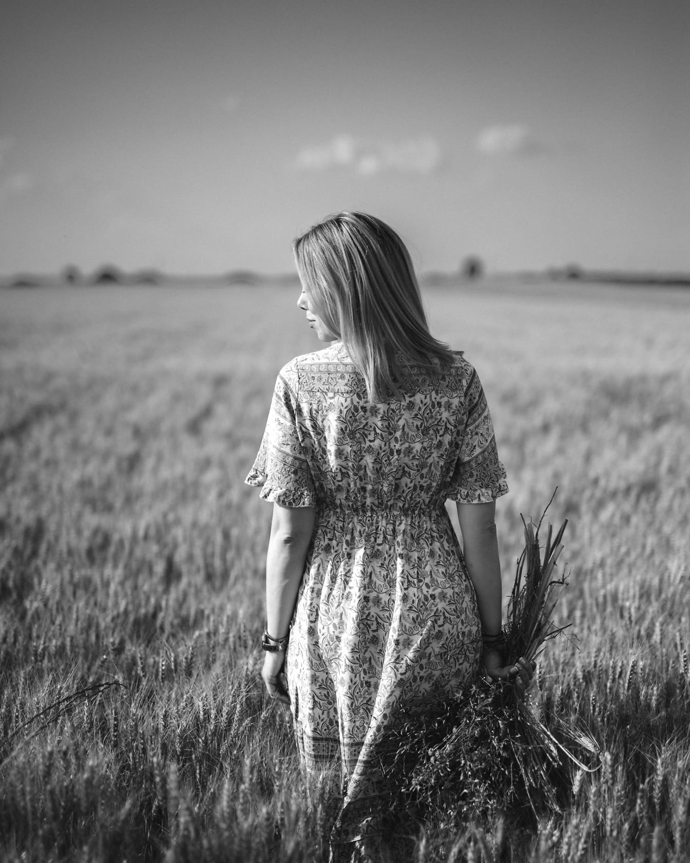 Блондинка сзади на пшеничном поле монохромная фотография