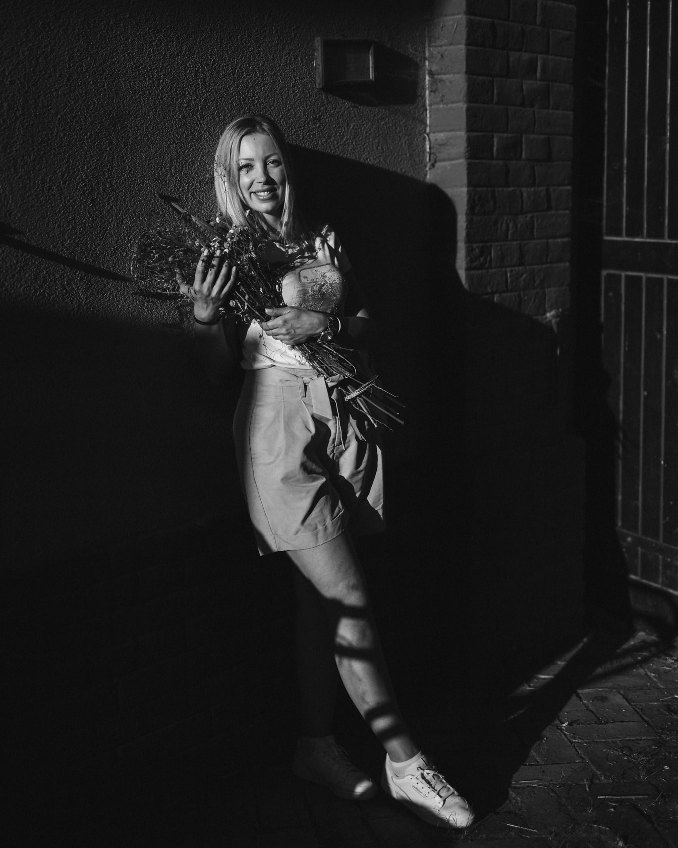 Hezká mladá žena s kyticí v rukou černobílá fotografie
