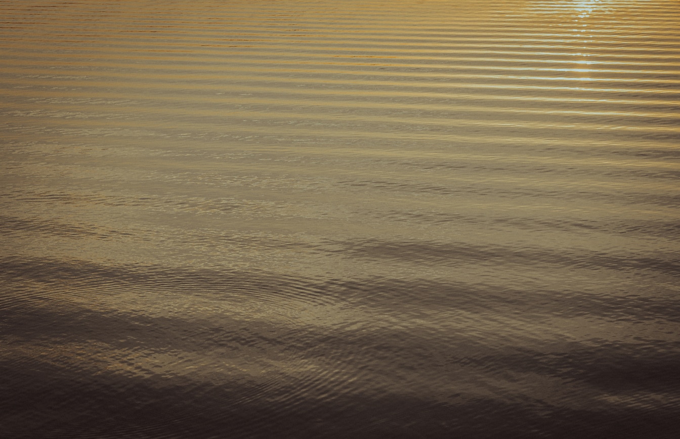 Nahaufnahme der Wasseroberfläche des Sees bei Sonnenaufgang