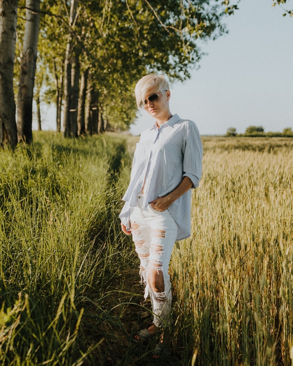 Žena fotomodelka v ležérnom oblečení vonku na pšeničnom poli