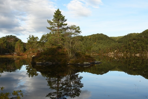 Buen tiempo en octubre, pequeña isla reflejada en el agua del lago