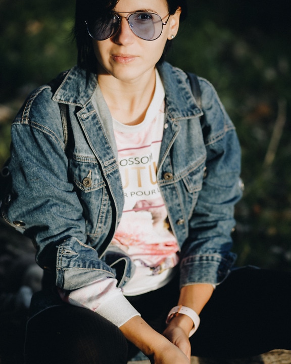 Portrait of gorgeous woman in denim jacket with sunglasses