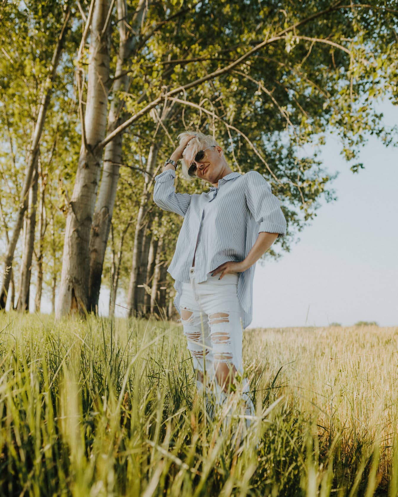 Modèle photo à la recherche de Goog dans un pantalon décontracté blanc dans la prairie