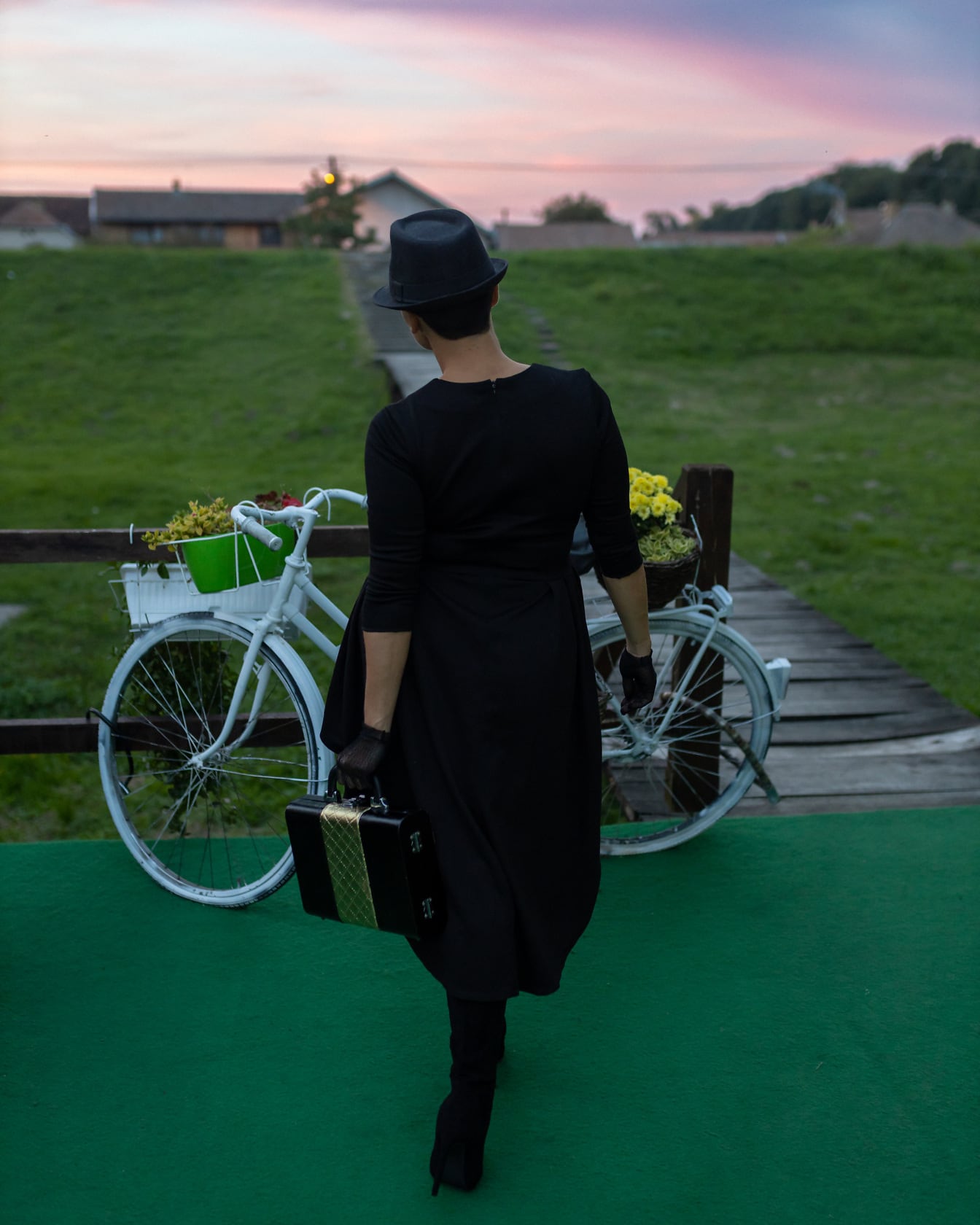 Žena nosí klasické čierne klobúkové šaty a čižmy oblečenie