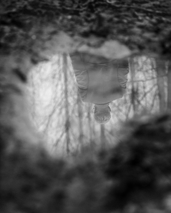 Monochrome photograph reflection of person in pond