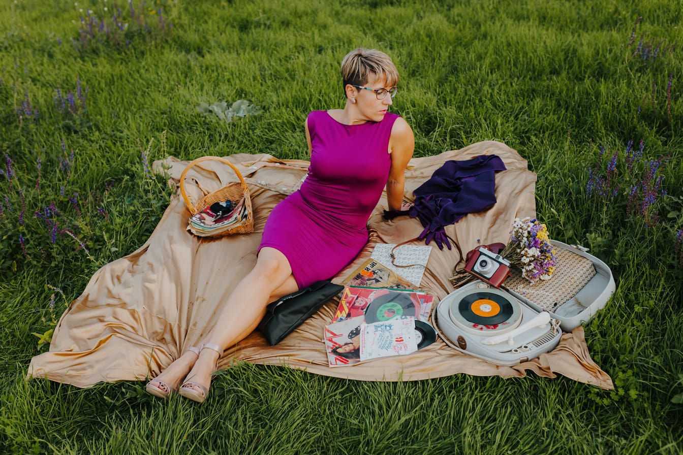 Hermosa dama sentada en la foto de nostalgia de la manta de picnic