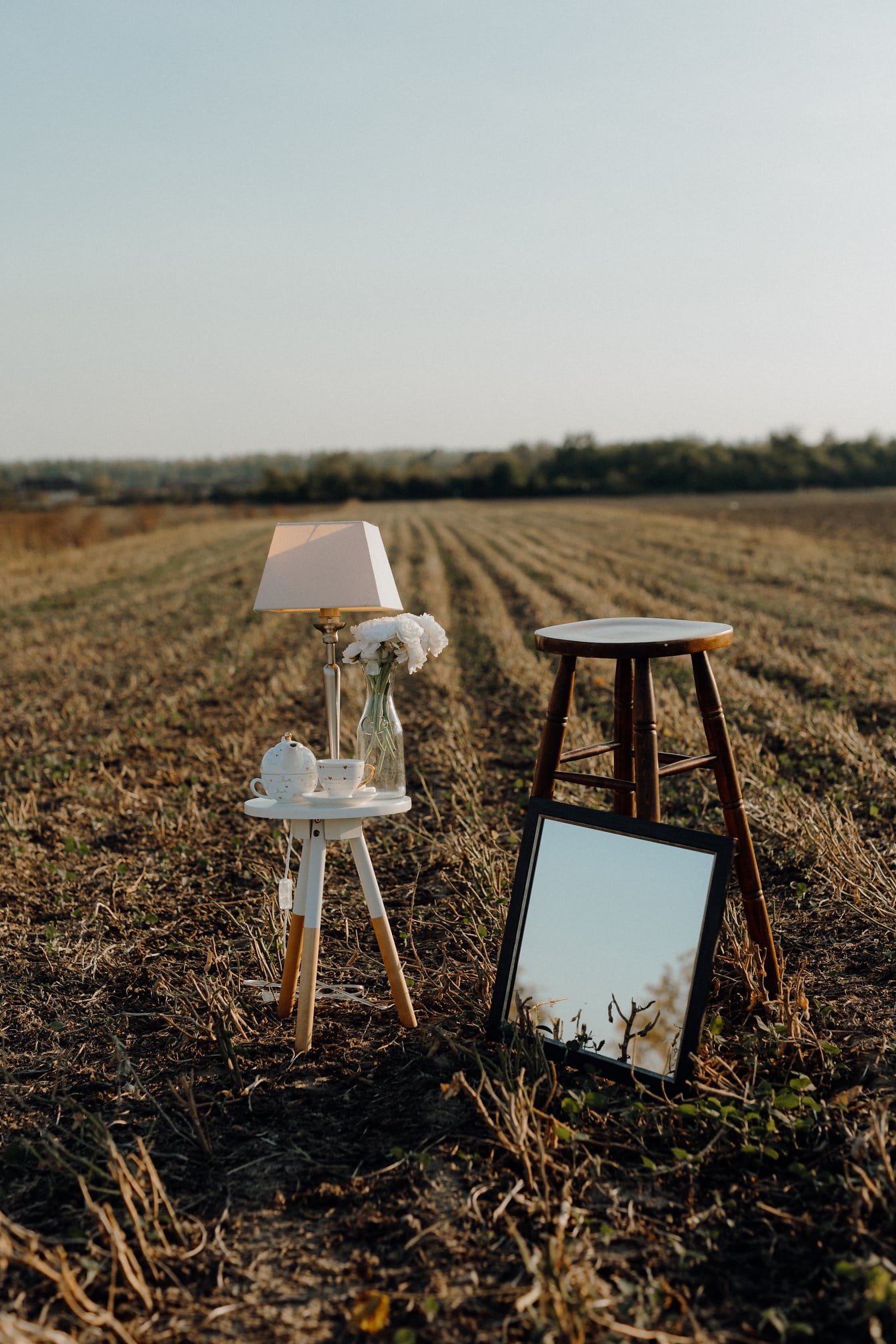 Rustikalna stolica i otmjena svjetiljka i čajnik fotografija mrtve prirode