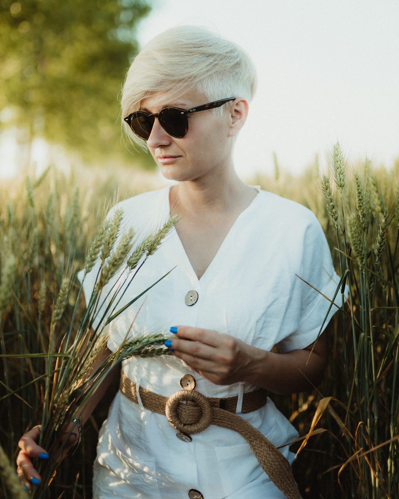 Entzückende Dame mit kurzen Haaren in weißem Kleid in Weizen