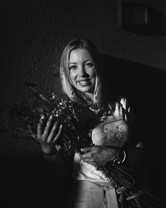 Adorable femme aux cheveux blonds avec bouquet photo monochrome