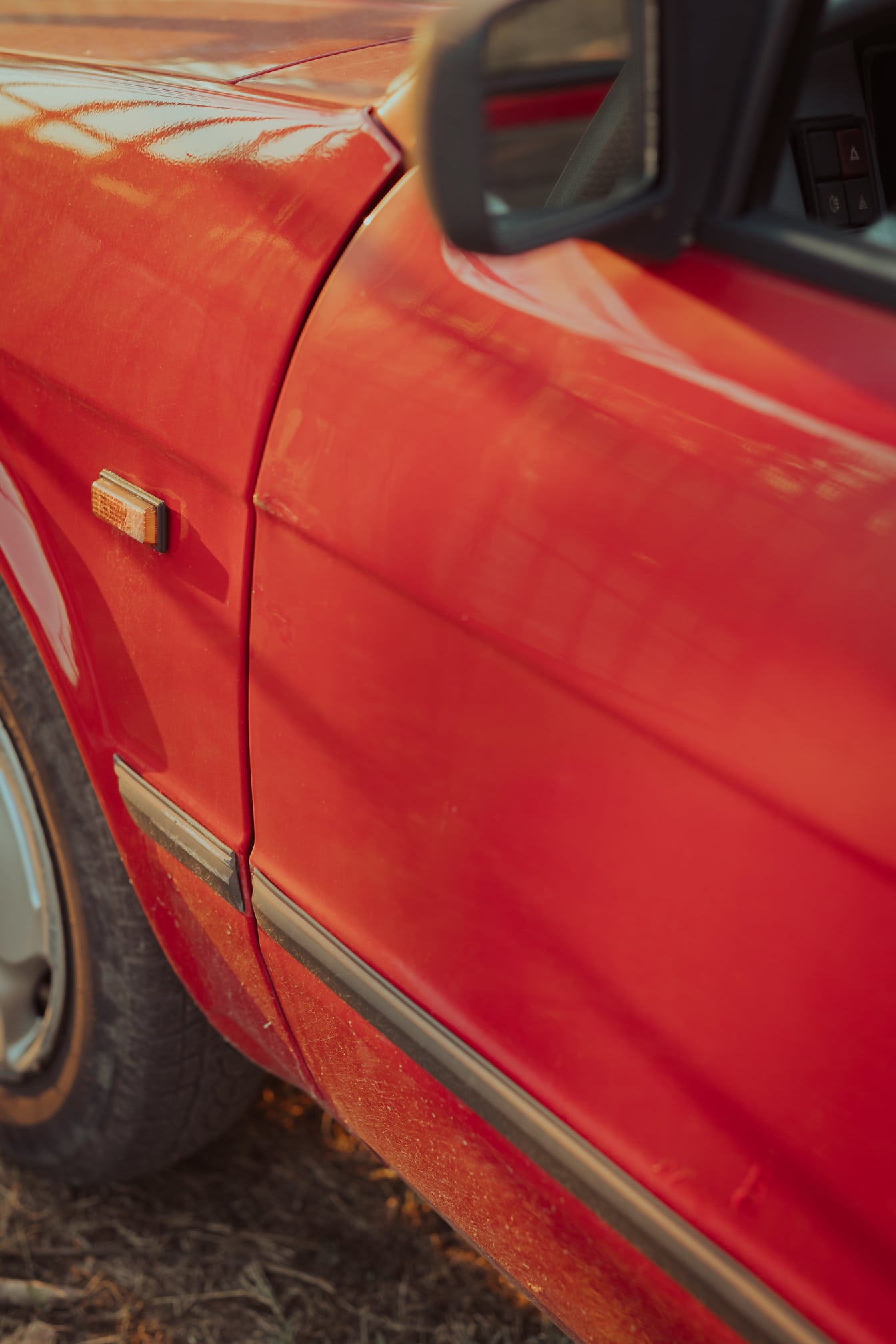 Close-updetail van spiegel van donkerrode sedanauto
