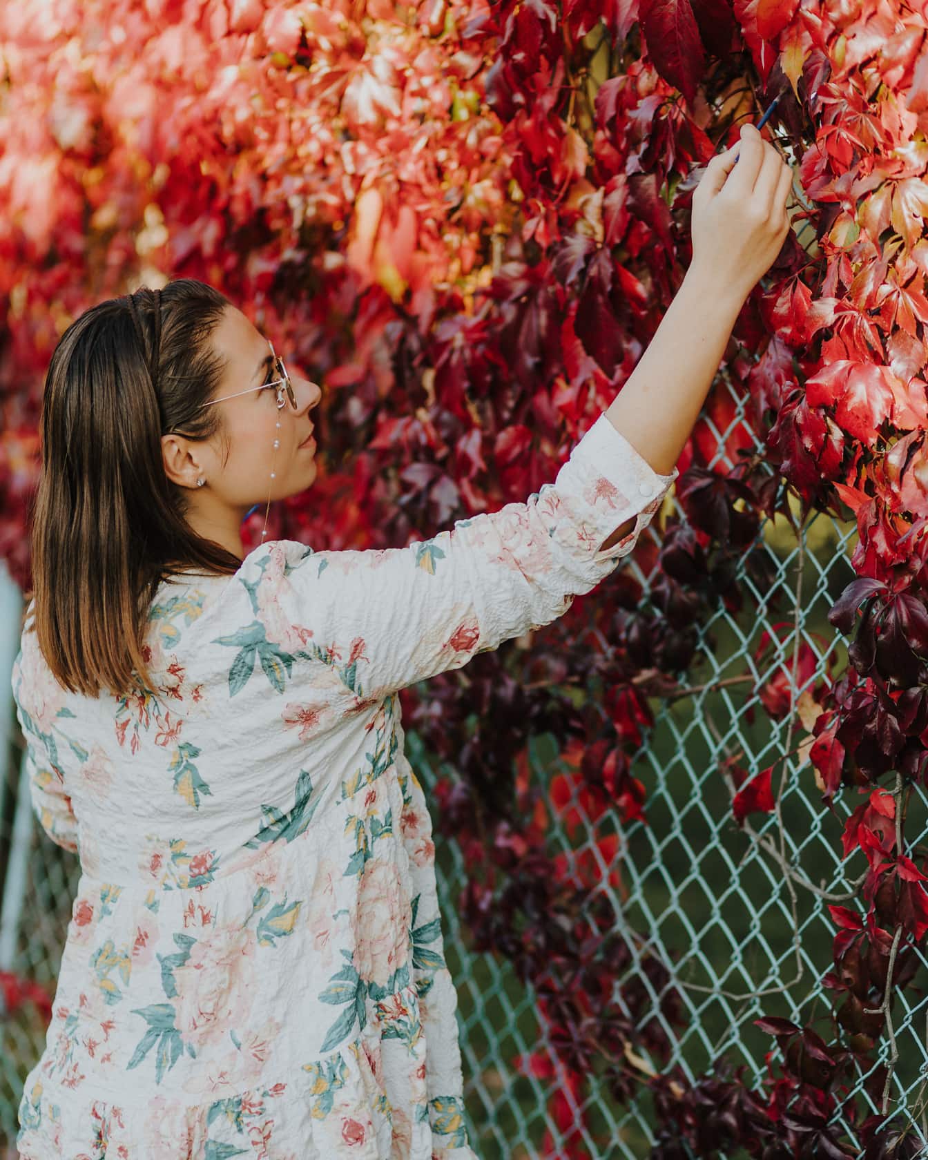 Artista de belas artes pintando folhas de outono na cerca
