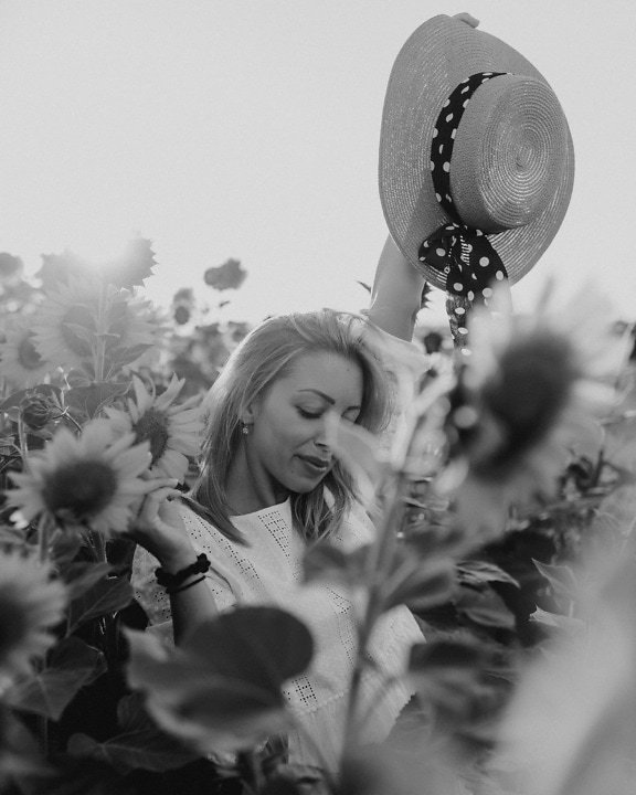 Cheerful blonde enjoying in sunflower field monochrome photo