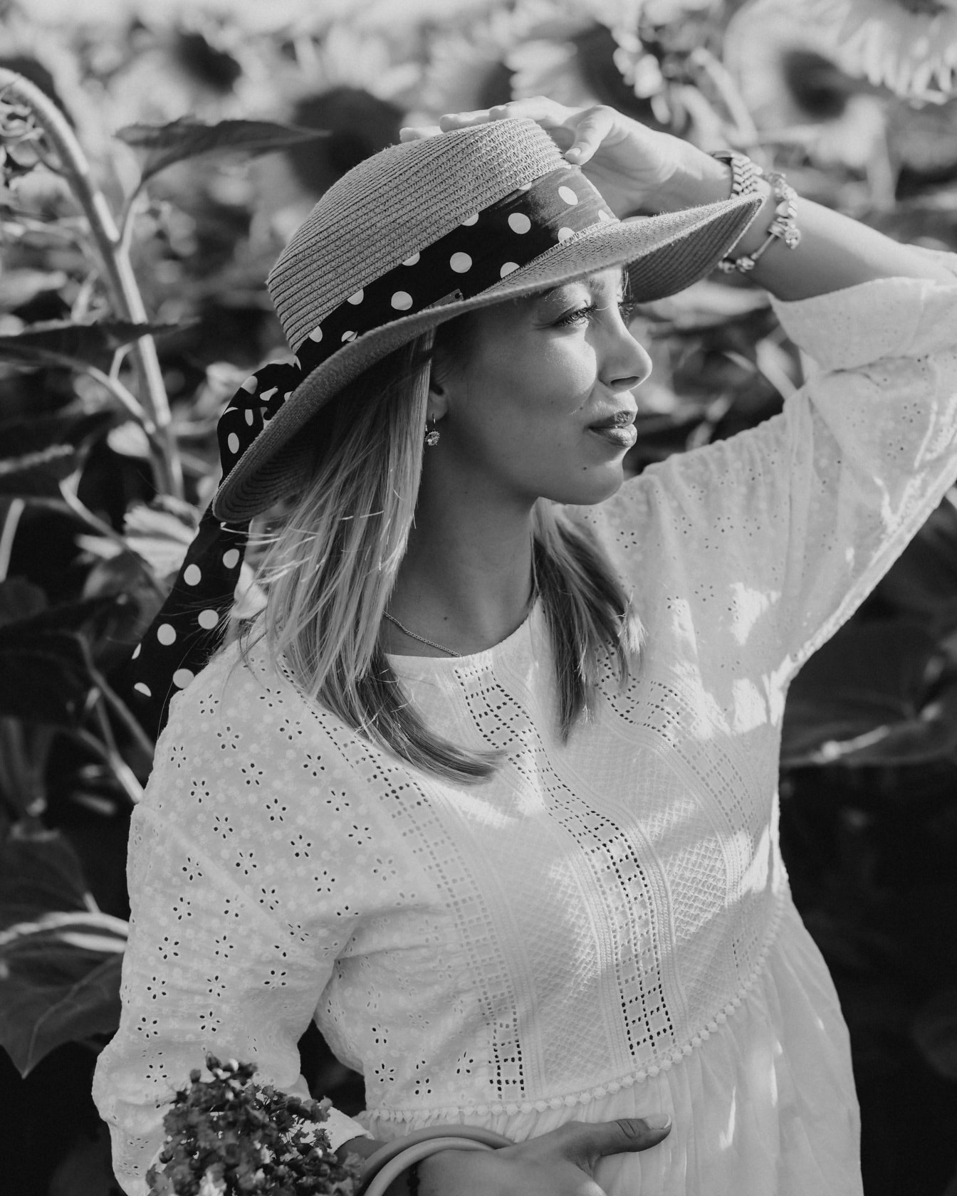 Portrait de blonde au chapeau de paille dans le champ de tournesols photo monochrome