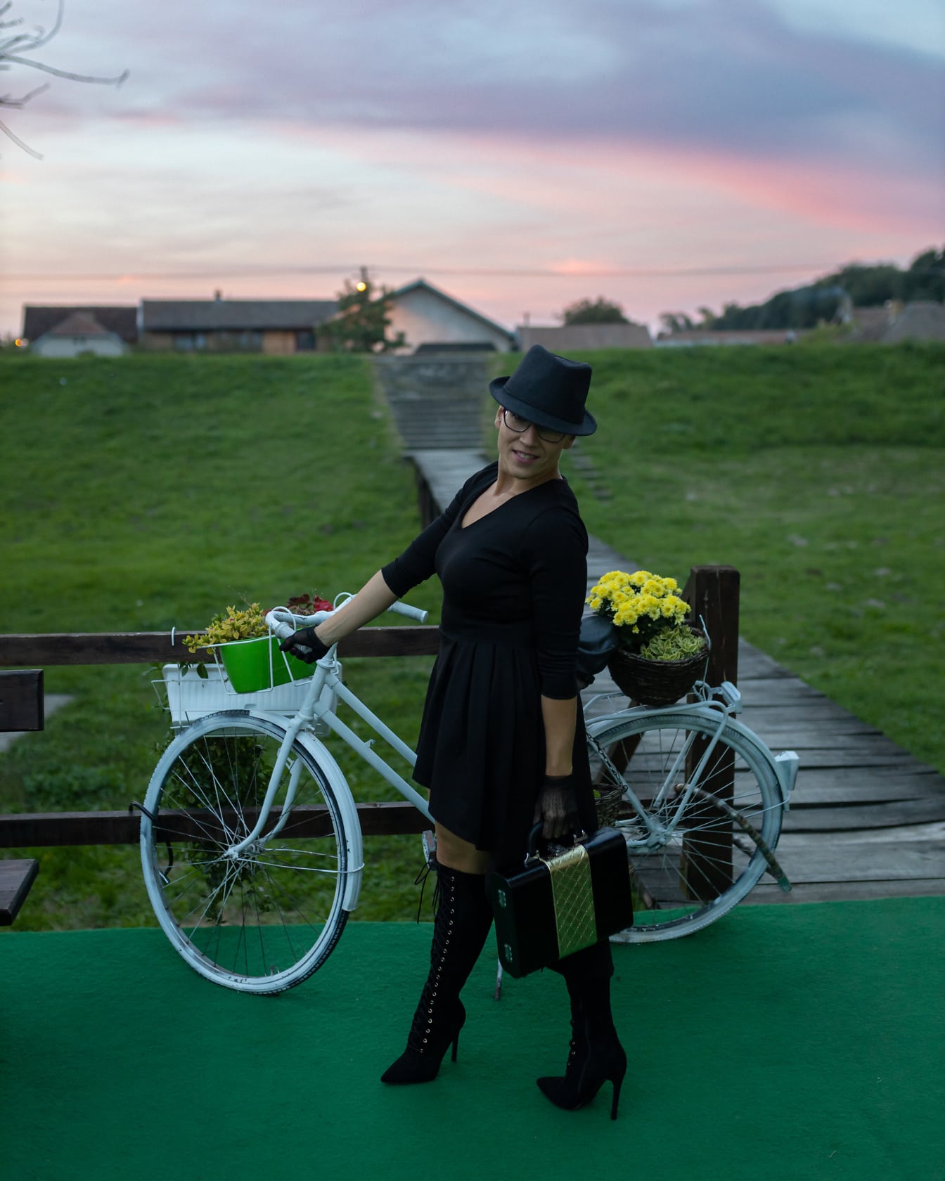 Bisikletli siyah elbiseli gülümseyen iş kadını