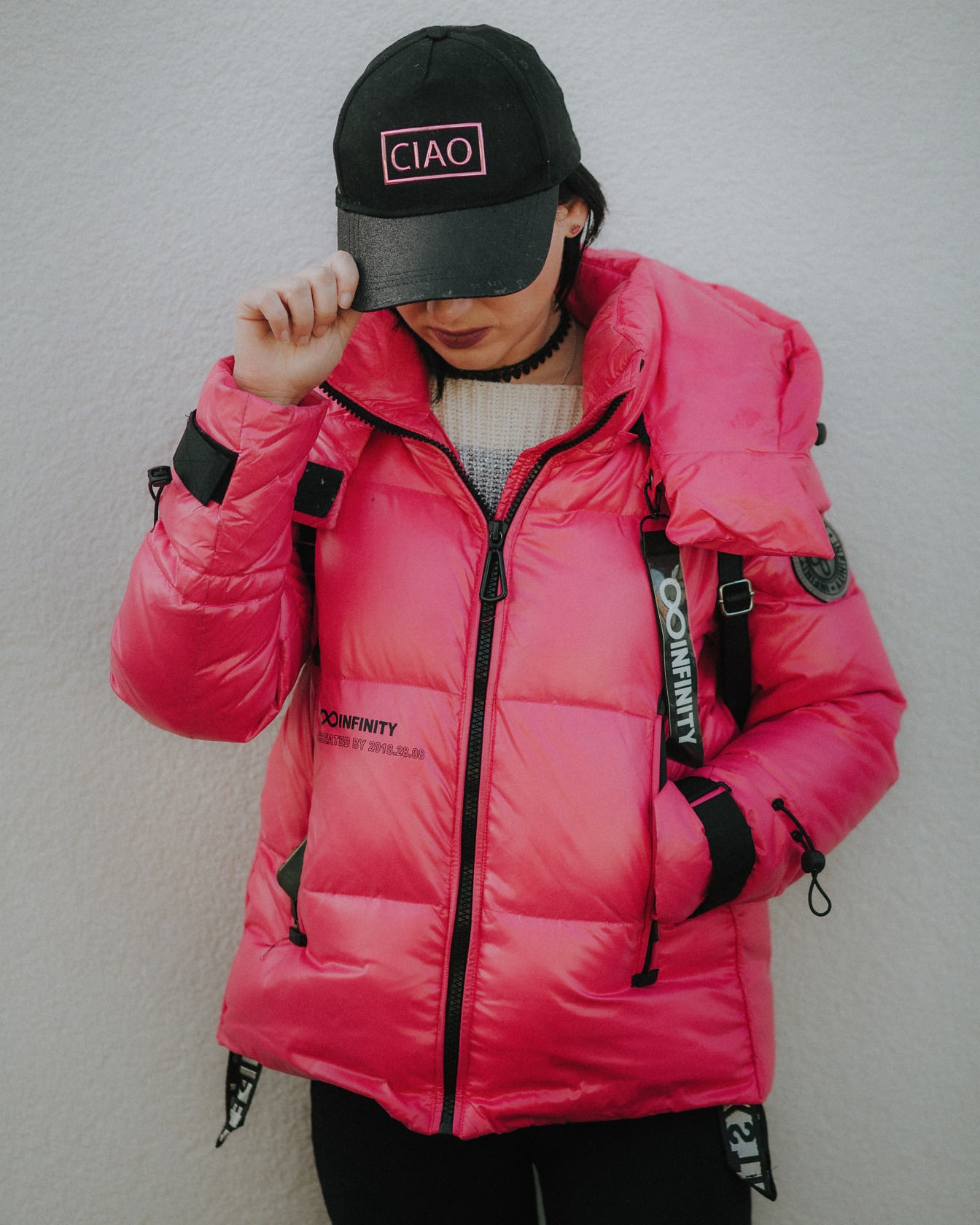 Model foto dengan jaket pink mewah dan topi hitam