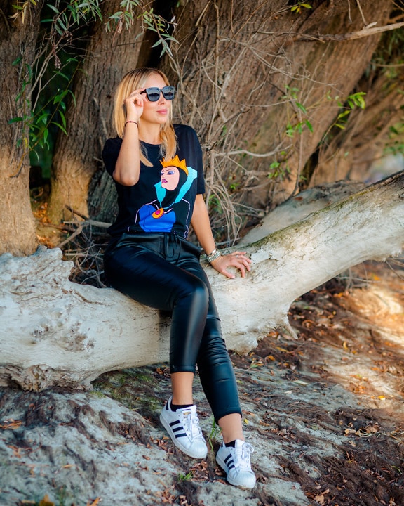 Portrait of blonde in black leather pants and fancy shirt