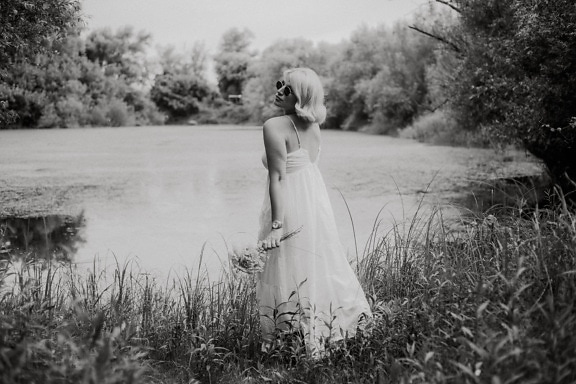 Gorgeous blonde in white dress by lakeside monochrome photo