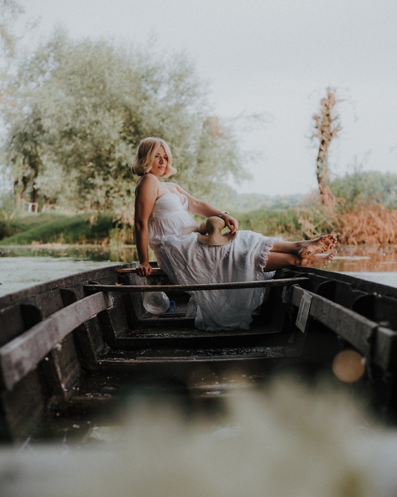 Pretty lady sitting and relaxing in wooden boat
