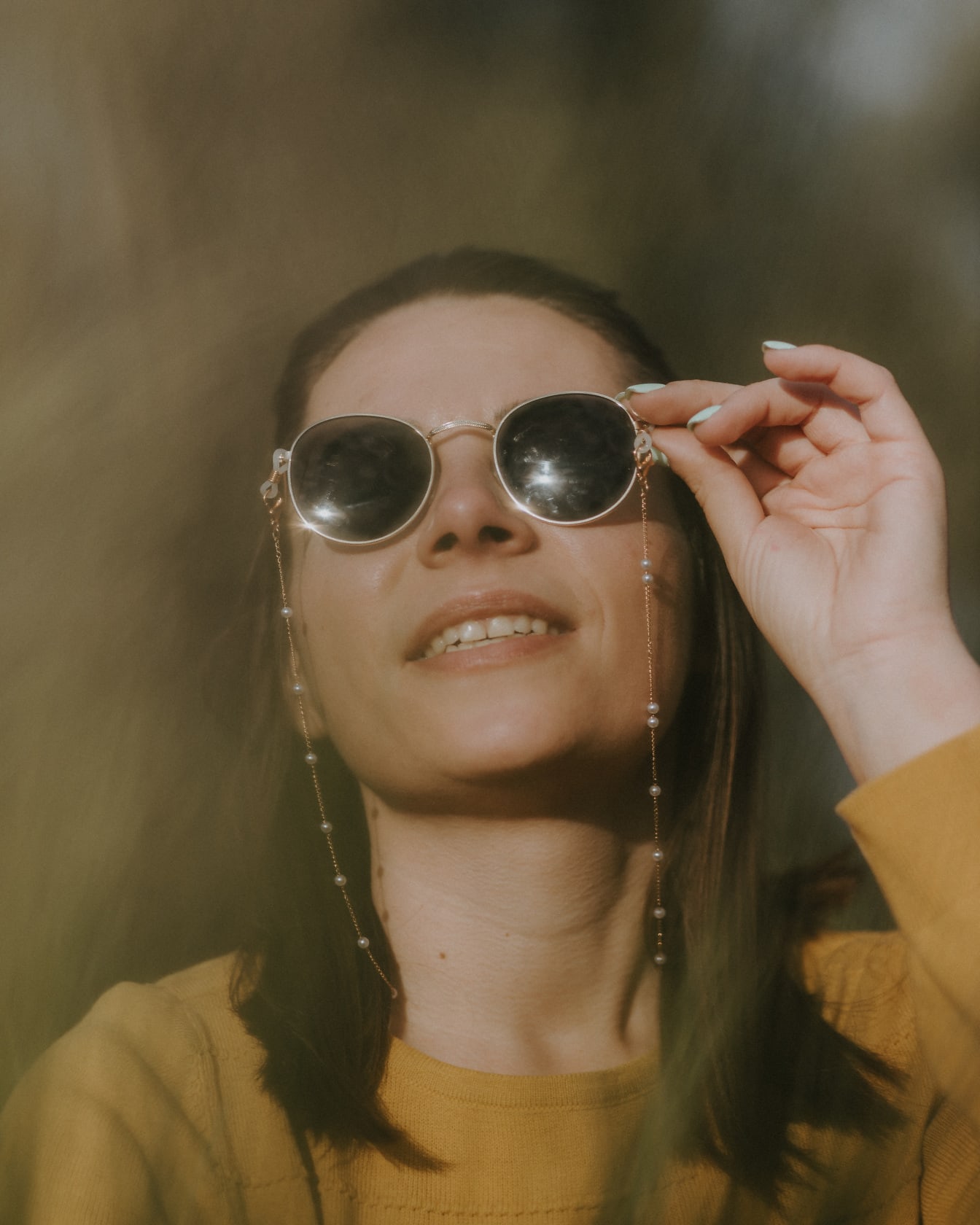 Veselá žena so slnečnými okuliarmi, usmievavá portrét zblízka