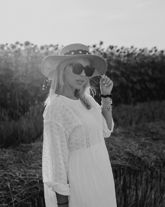 Pretty blonde with straw hat and sunglasses on sunny day