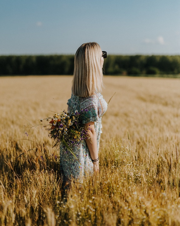 Blondýnka v rustikálním tradičním oděvu v pšeničném poli