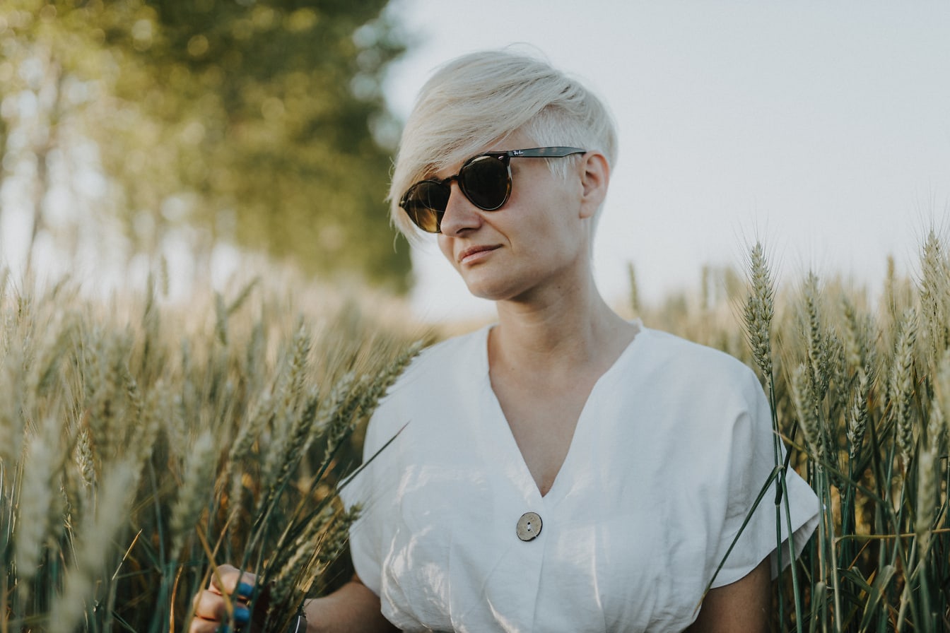 Dobre vyzerajúca žena v bielej košeli na pšeničnom poli
