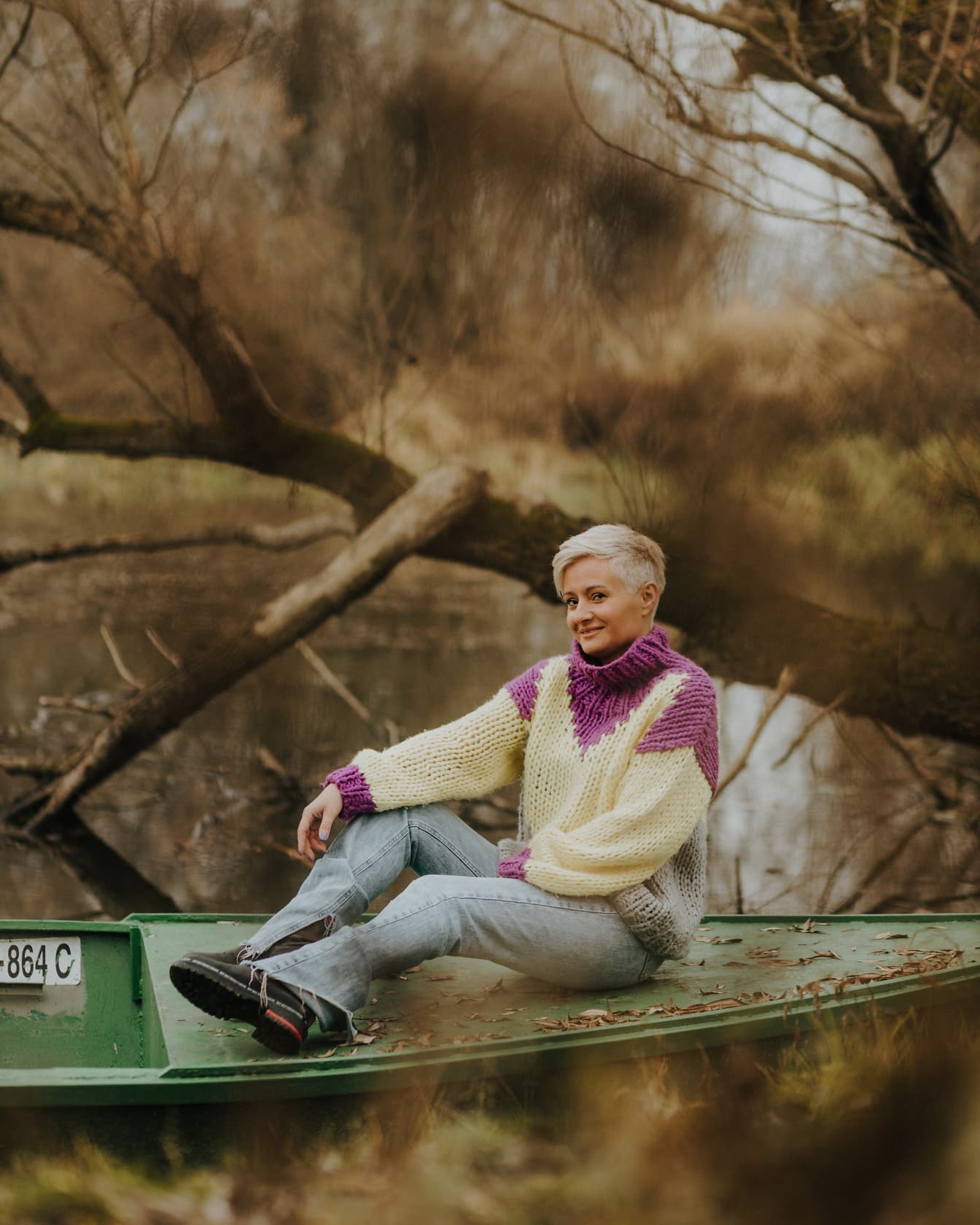 Woman sitting in boat in handmade wood sweater