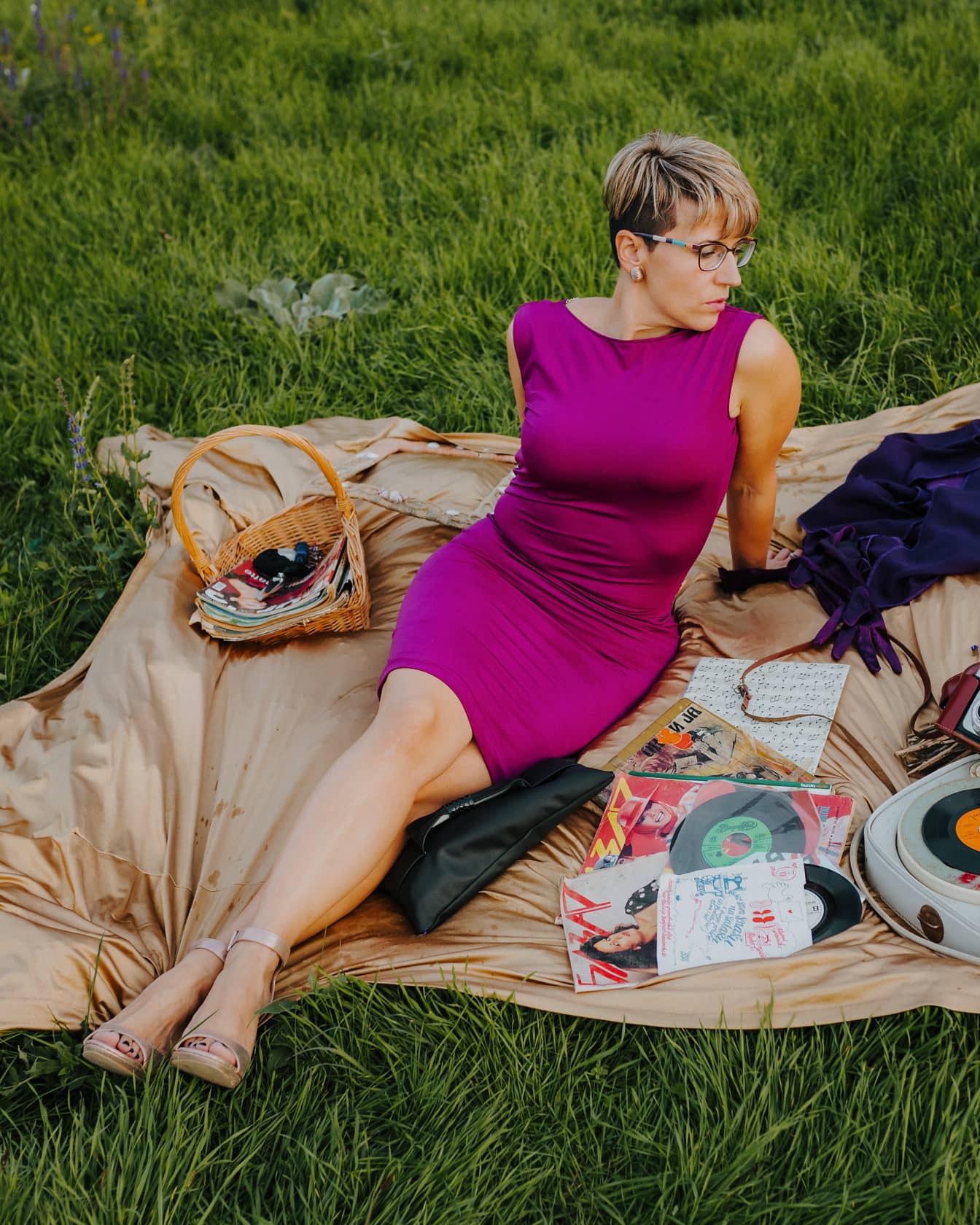 Gyönyörű fotómodell pózol pikniken lila ruhában
