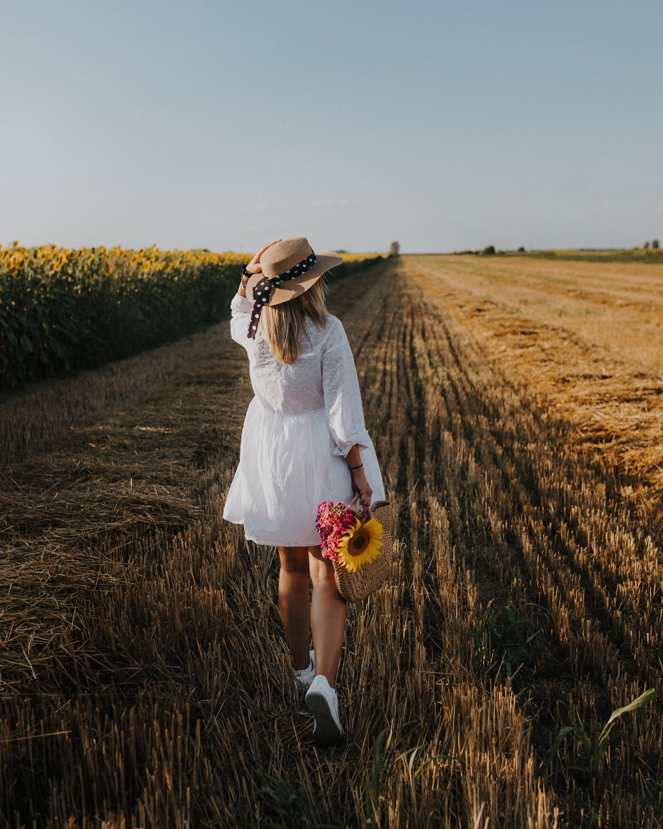 Белое платье и шляпа на женщине на пшеничном поле