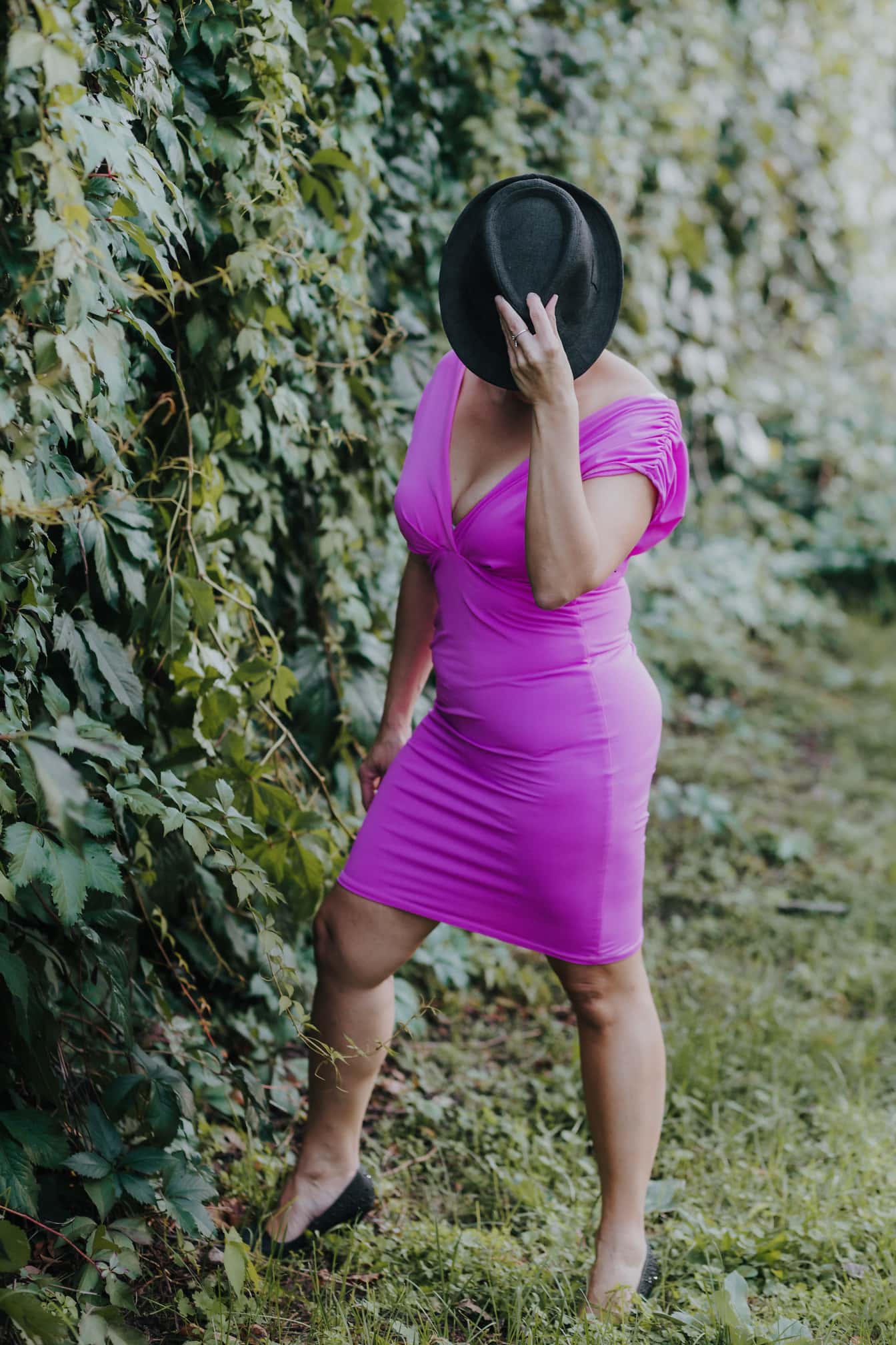 Bizneswoman w fioletowej sukience i czarnym kapeluszu