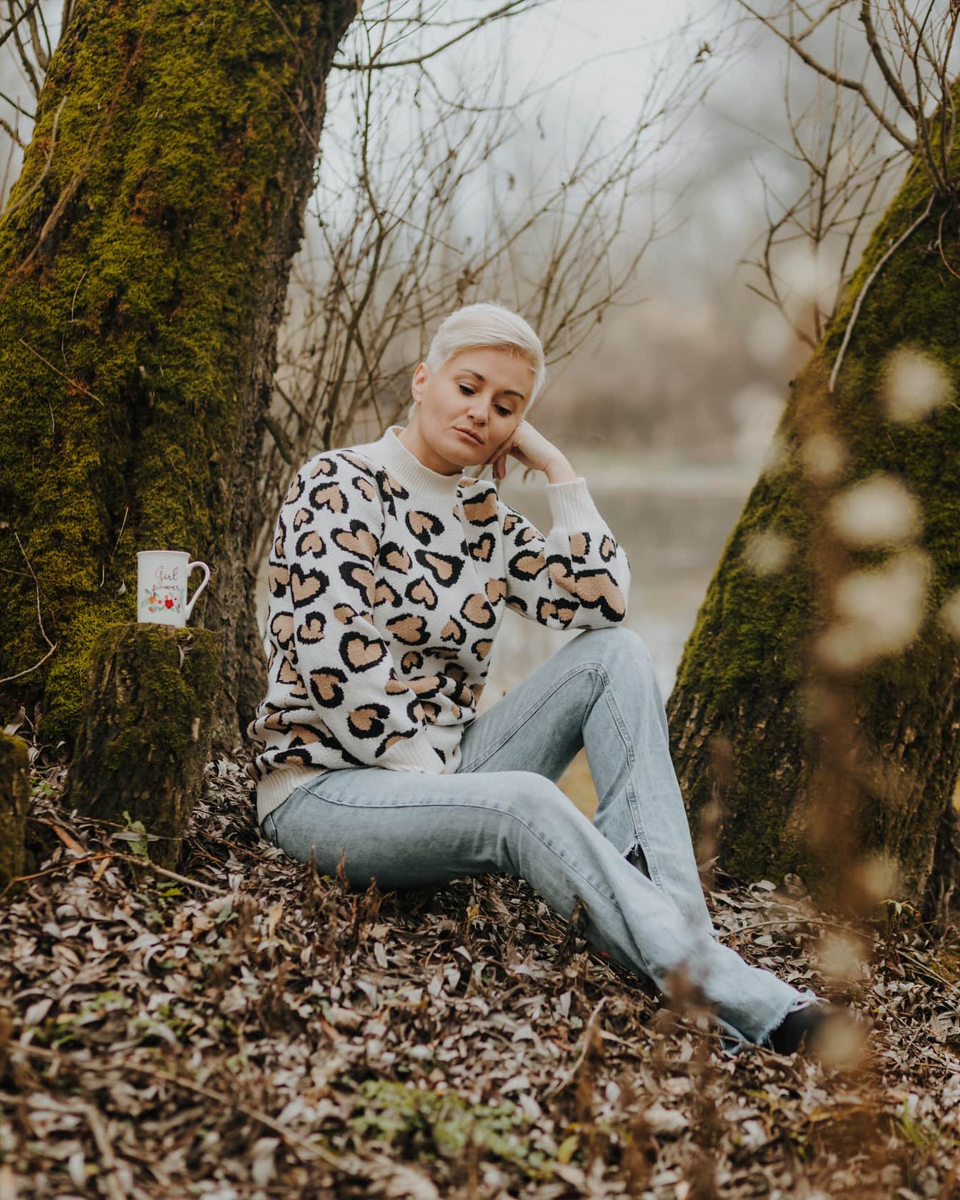 Short hair blonde sitting in sweater and jeans pants