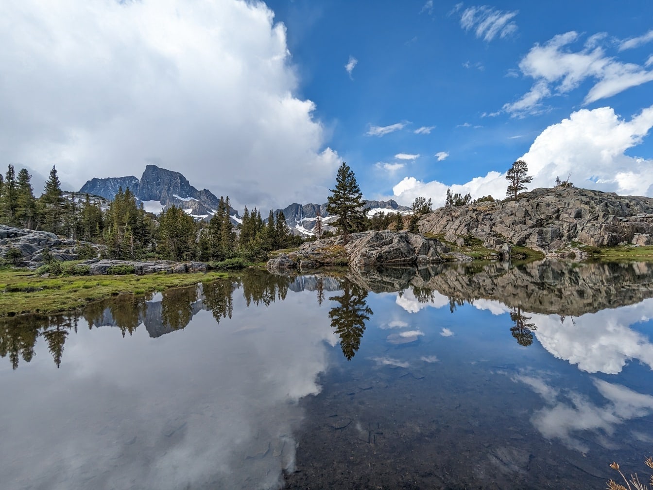 Величественная панорама берега озера с отражением облачно-голубого неба