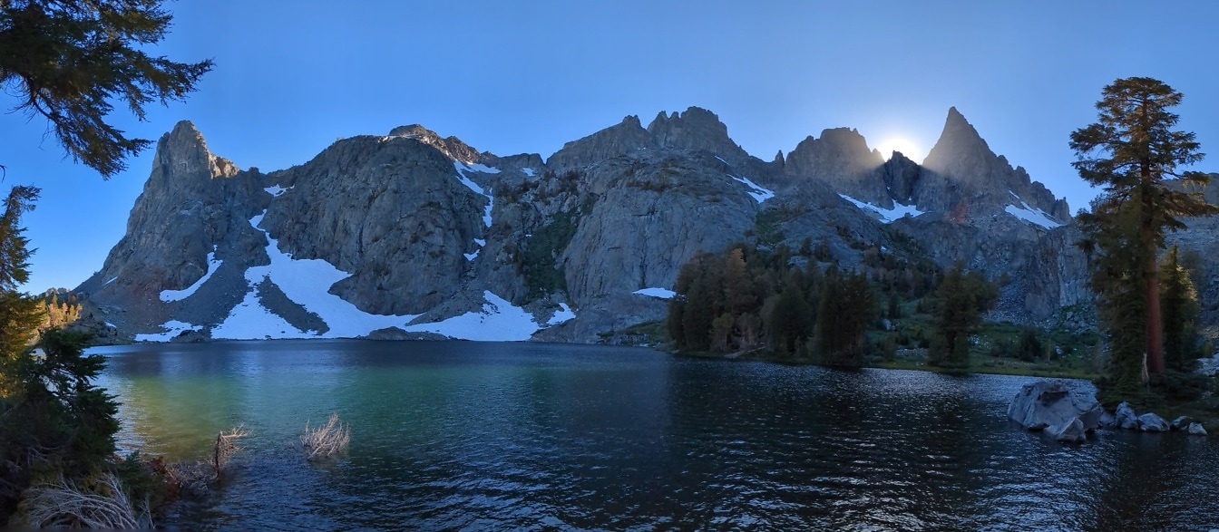 Mammoth lakeside in dawn with sunrays behind mountain peaks