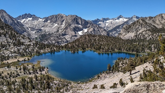Panorama of High Sierra natural park with dark blue lake