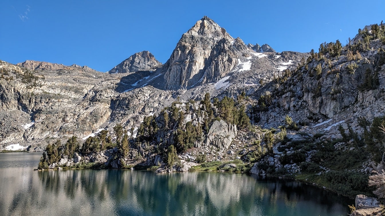 Reflexão do pico da montanha alta no lago da montanha