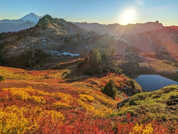 Paisagem majestosa da encosta da montanha com raios solares na estação de outono