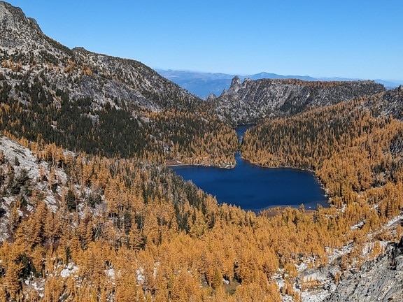 Panoramatická krajina v údolí podzimní sezóny s modrým jezerem