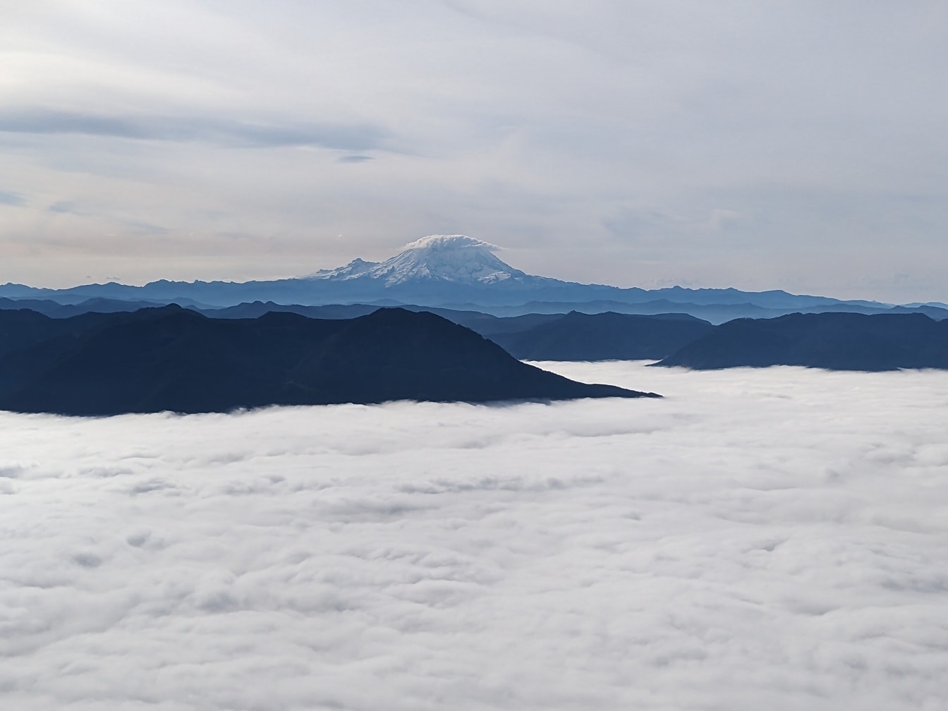 Majestætisk panorama af bjerge over skyer