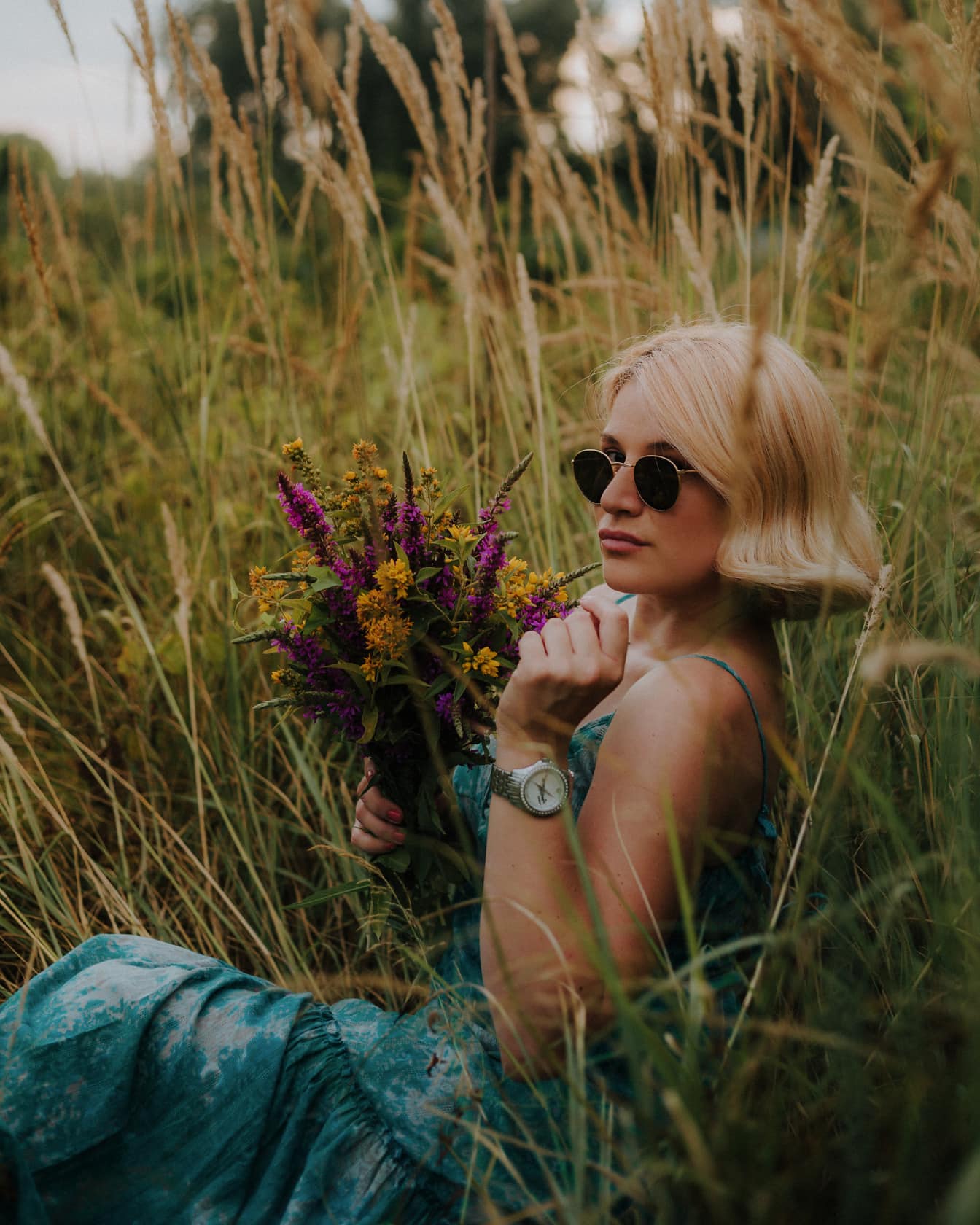 Gorgeous blonde in grass with bouquet of flowers