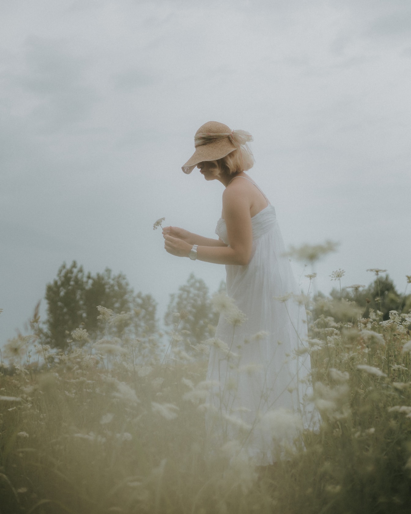 Mujer joven en vestido blanco clásico en prado