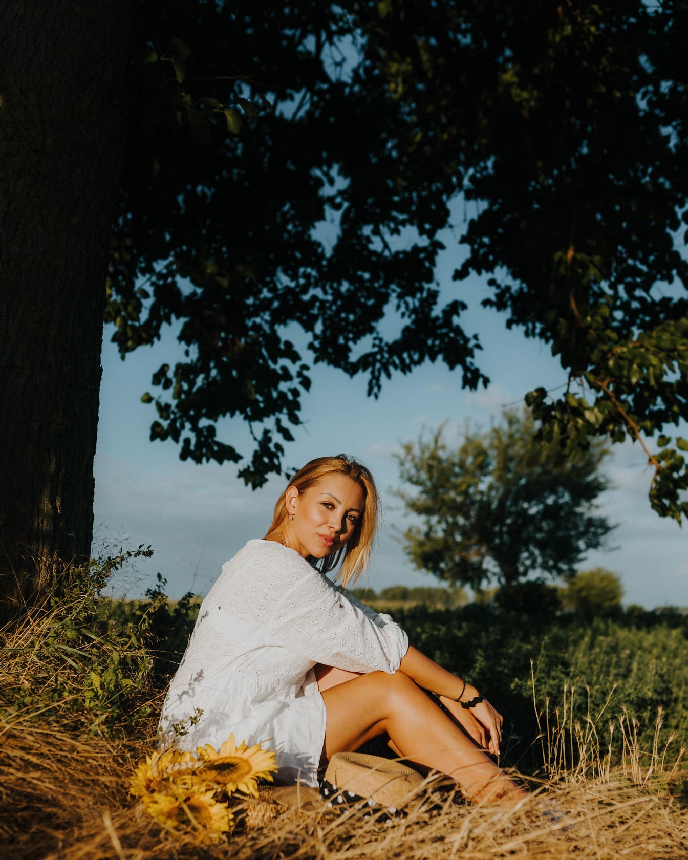 Gorgeous blonde photo model sitting in countryside