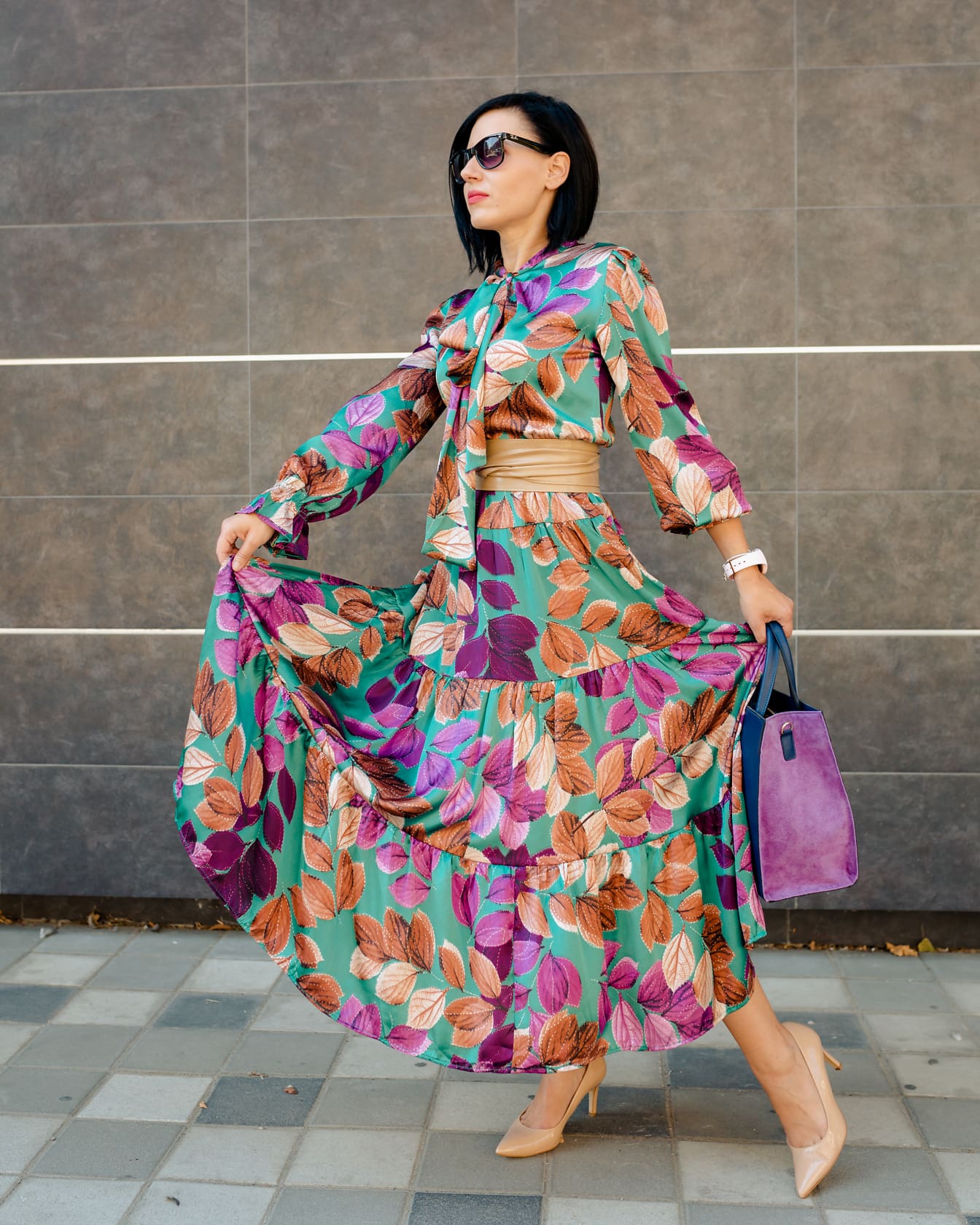 Επιχειρηματίας με κομψό πολύχρωμο μεταξωτό φόρεμα και μωβ τσάντα